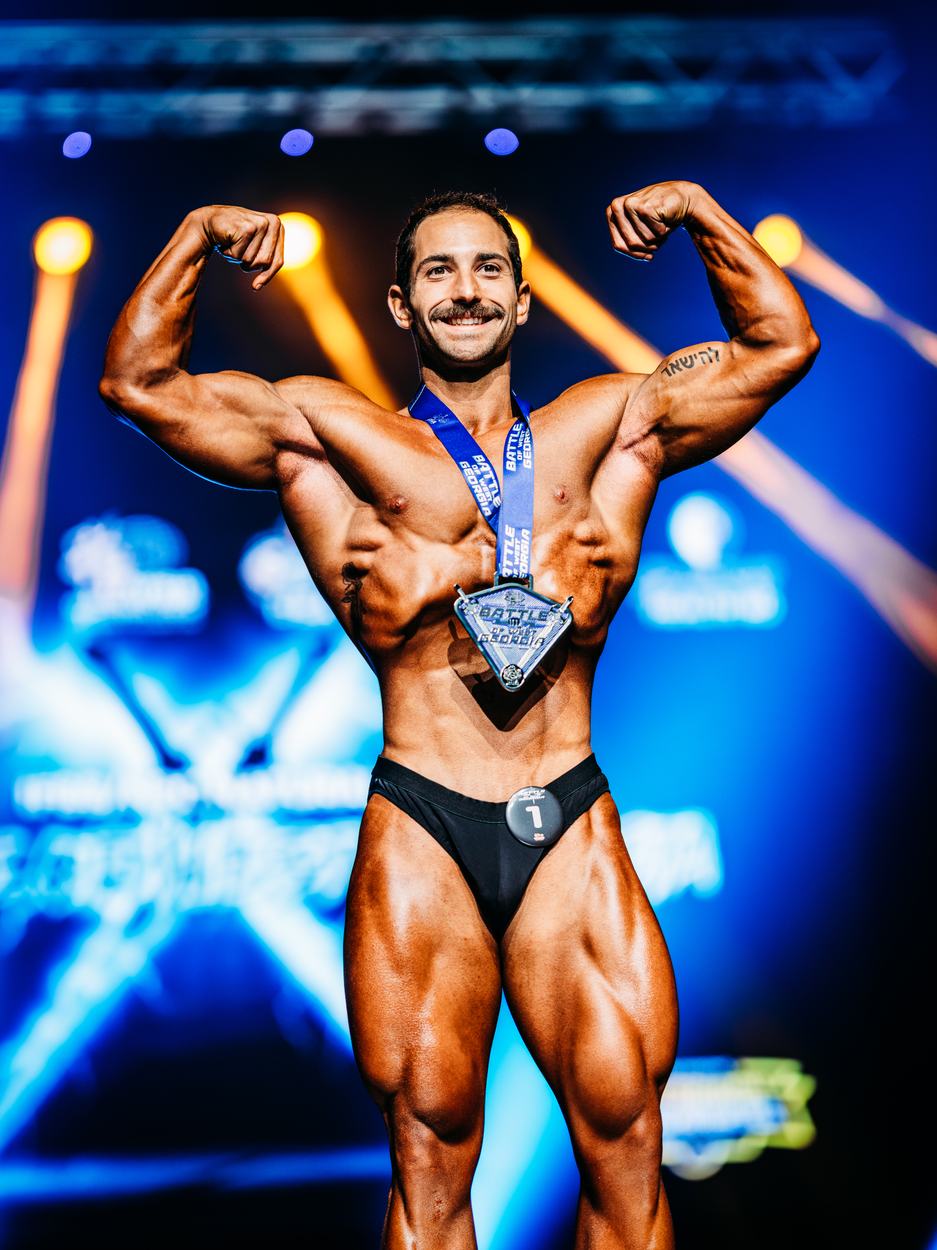 Jeremy Womack on stage at Battle of West Georgia 2026, front double biceps
